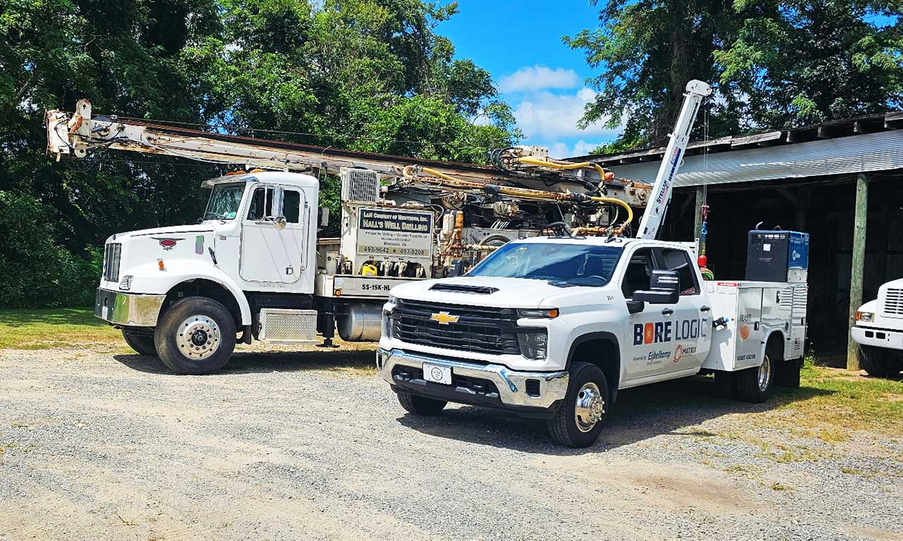 Bore Logic maintenance truck and drill rig parked at operations yard for equipment inspection.