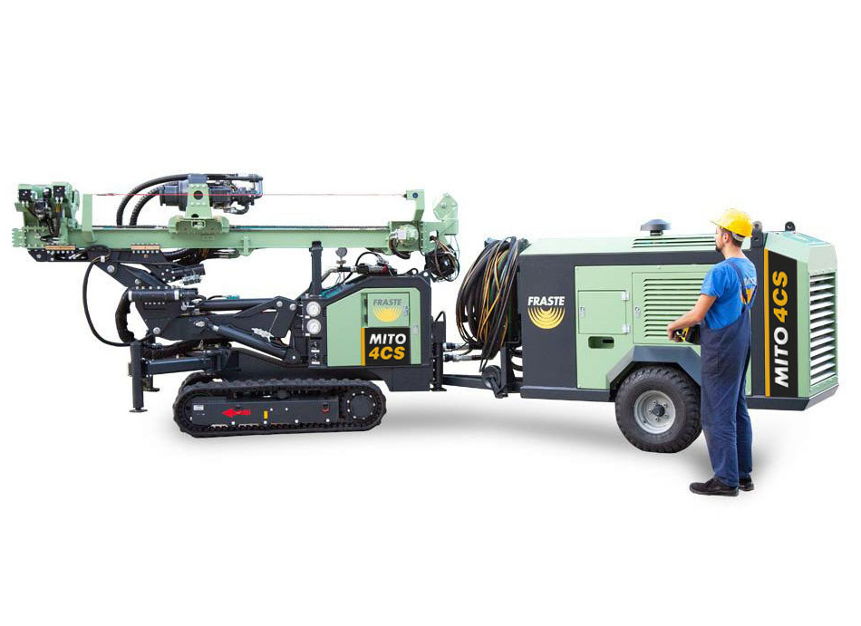 Technician standing beside a Fraste MITO 4CS drilling rig with tracked base and compact compressor unit, designed for geotechnical drilling applications.