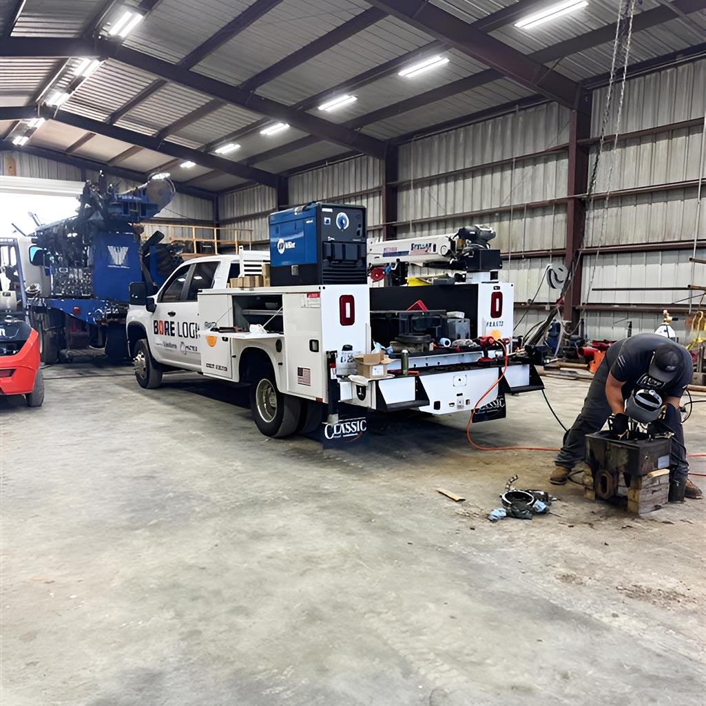 Technician repairing drilling equipment inside Bore Logic service facility to reduce downtime.