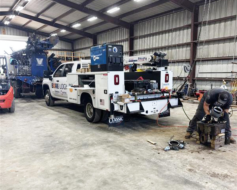 Technician repairing drilling equipment inside Bore Logic service facility to reduce downtime.